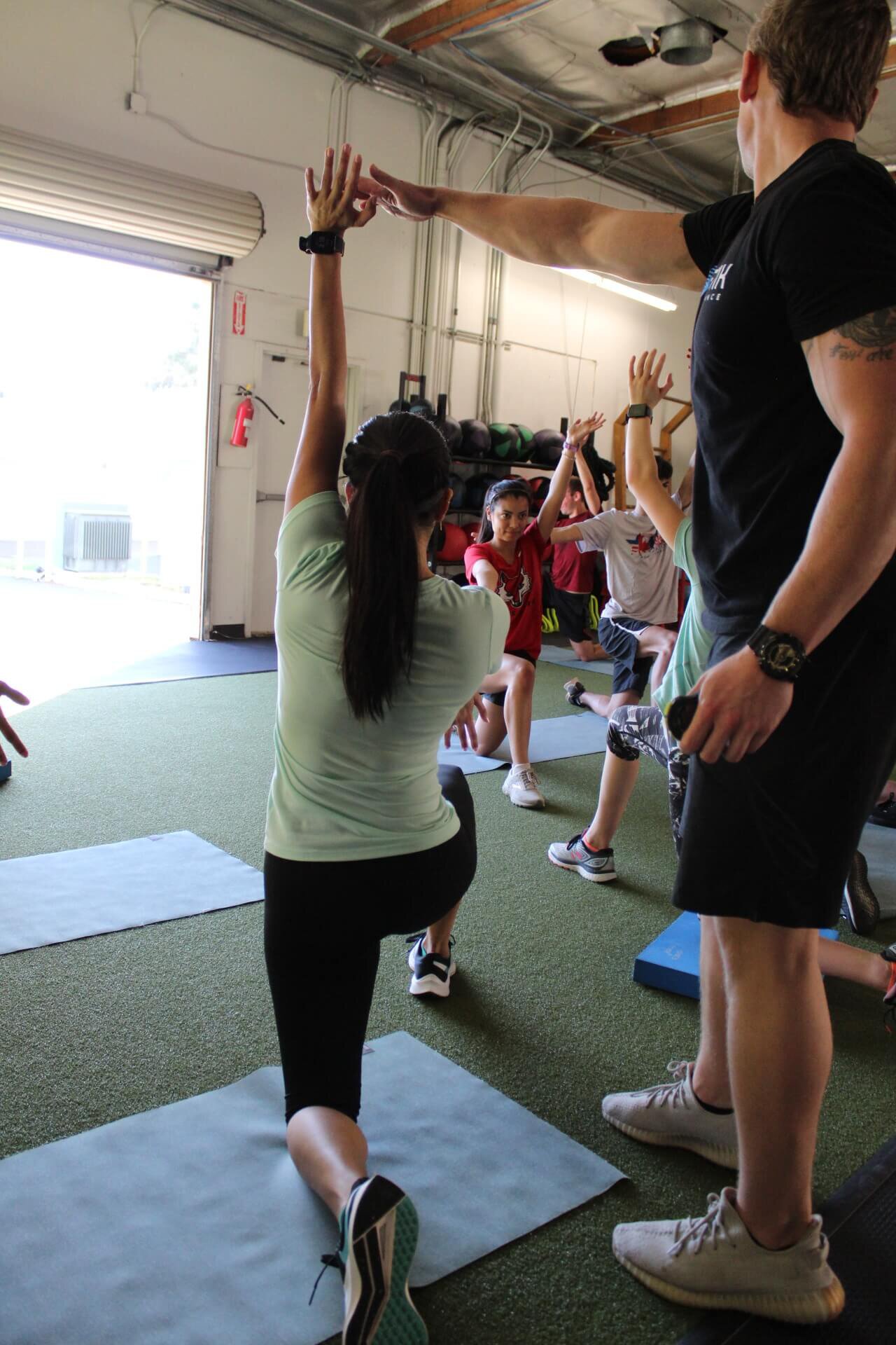 Trainer assisting an athlete with a myofasical stretch exercise