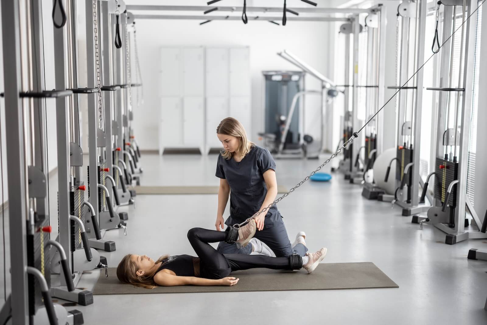 Trainer instructing athlete with cable machine
